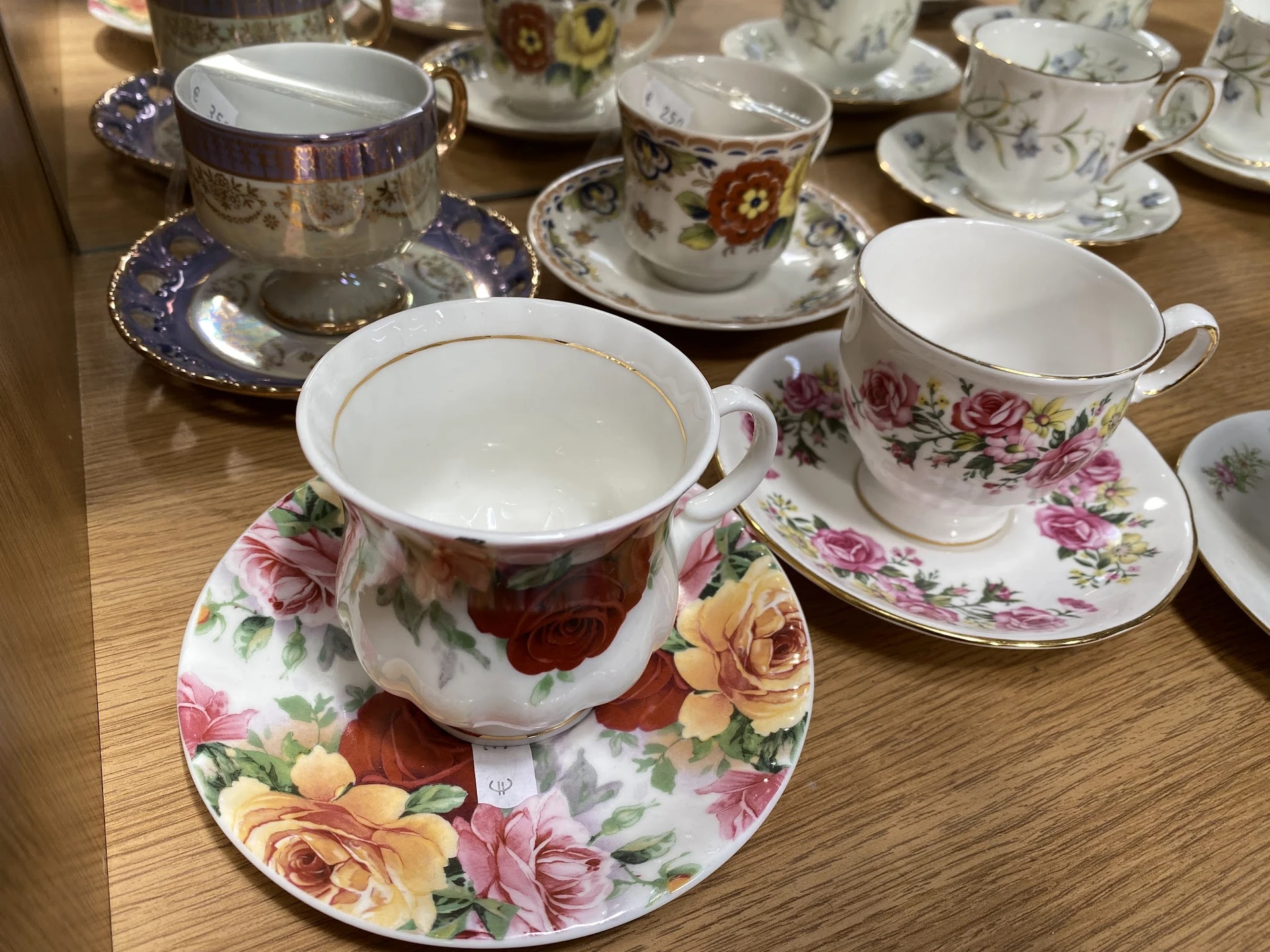Verzameling vintage porseleinen theeservies met bloemmotieven op houten tafel