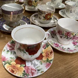 Verzameling vintage porseleinen theeservies met bloemmotieven op houten tafel