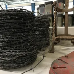 Grote balen samengeperst zwart materiaal op de fabriekshal, mogelijk gerecyclede kabels of kunststof