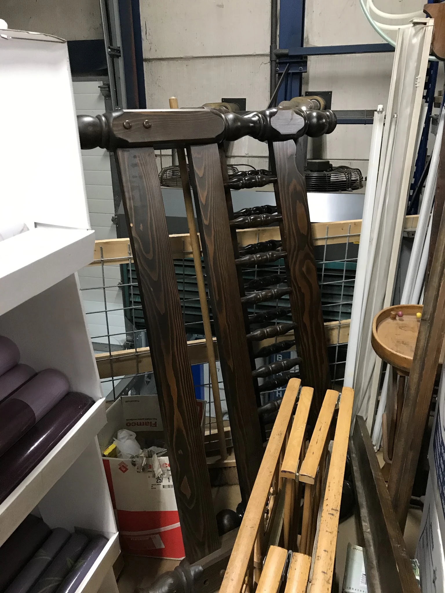 Interieur van kringloopwinkel met stellingen vol zwarte elektronicaartikelen en houten meubels