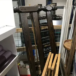 Interieur van kringloopwinkel met stellingen vol zwarte elektronicaartikelen en houten meubels