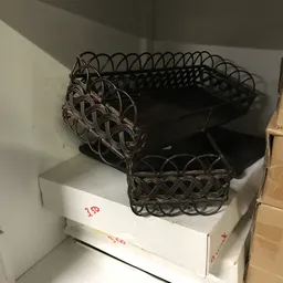 Zwarte manden met decoratief vlechtwerk gestapeld op een doos