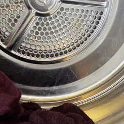 Close-up van de trommel van een wasmachine met gaatjespatroon
