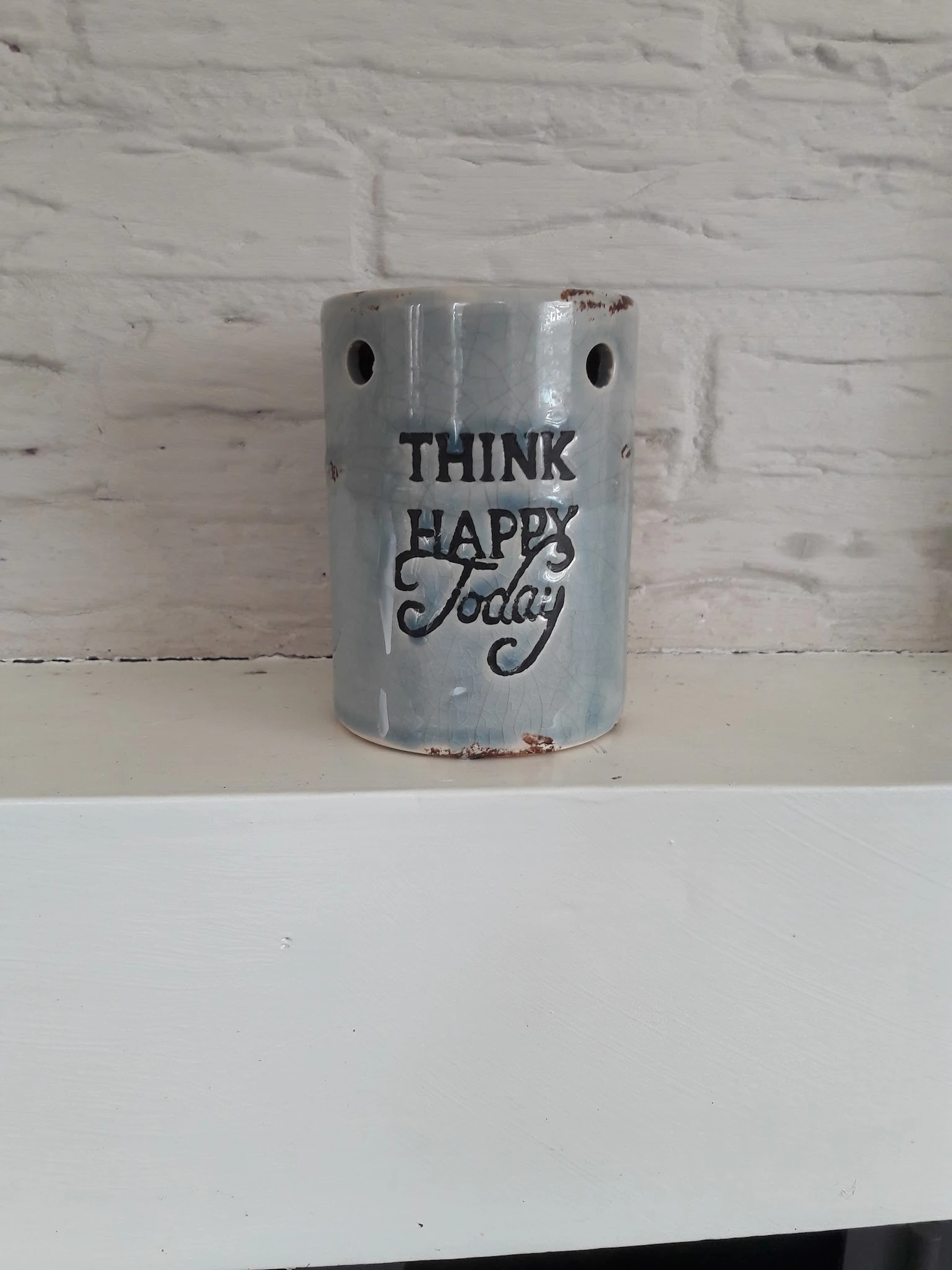 Grijze keramische houder met tekst 'THINK HAPPY Today' en twee gaten aan de bovenkant