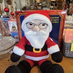 Handgemaakte gebreide kerstman pop met rode outfit, witte baard en bril