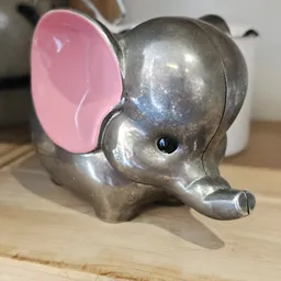 Close-up van een zilveren olifantbeeldje met roze oren