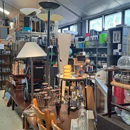 Winkelvloer met diverse tweedehands spullen, meubels, lampen en huisraad uitgestald in de kringloopwinkel