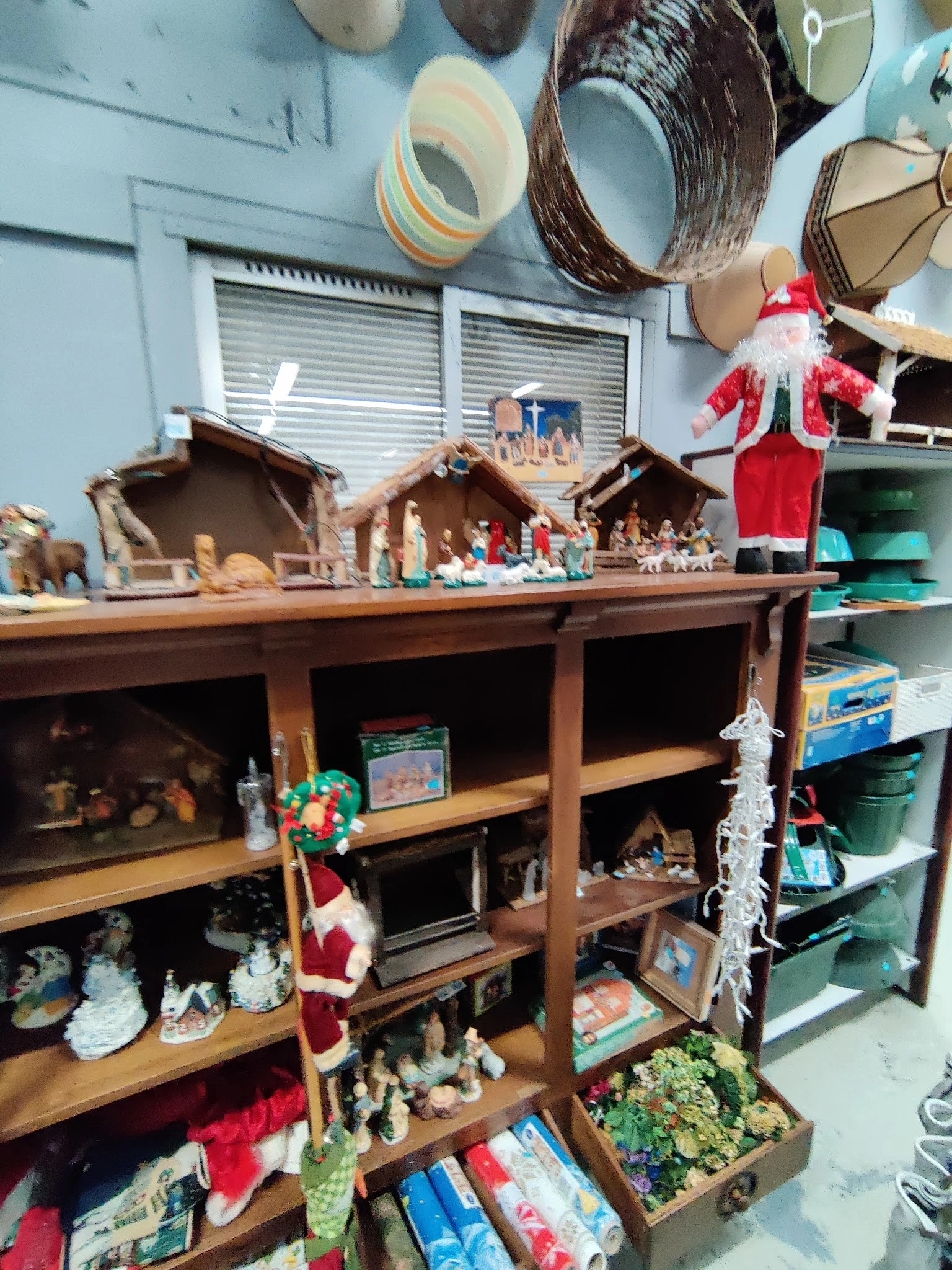 Houten stellingkast met kerststallen, beeldjes en decoraties uitgestald