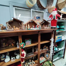 Houten stellingkast met kerststallen, beeldjes en decoraties uitgestald