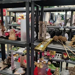 Winkelinterieur met stellingen vol kleding, bloemen, plantenrekken en diverse tweede-hands artikelen