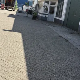 Stoep en ingang van een winkelpand met gesloten deuren en witte kozijnen