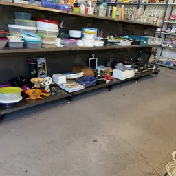 Diverse huishoudelijke artikelen en serviesgoed op een zwarte stellage in de winkel