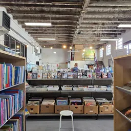 Uitgestalde tweedehands boeken, dvd's en media op stellingen en in dozen in de winkel