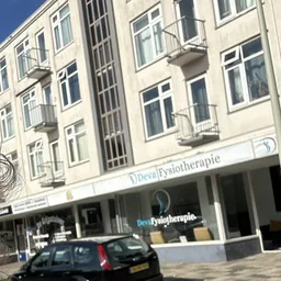 Gevel van een wit gebouw met fysiotherapiepraktijk op de begane grond in Den Haag