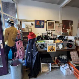 Vitrinekast met vintage vinyl, boeken, tickets en verzamelaars items in een kringloopwinkel