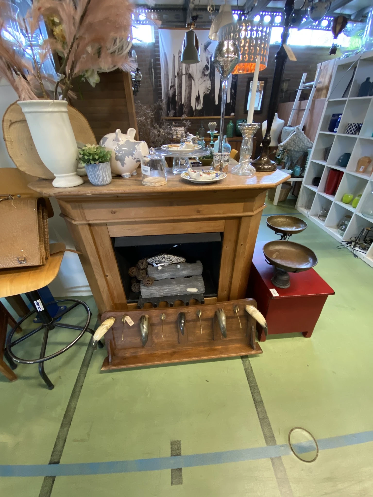 Houten meubel met open vak en uitschuiflade met bestek, versierd met decoratieve objecten bovenop
