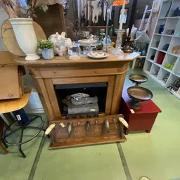 Houten meubel met open vak en uitschuiflade met bestek, versierd met decoratieve objecten bovenop