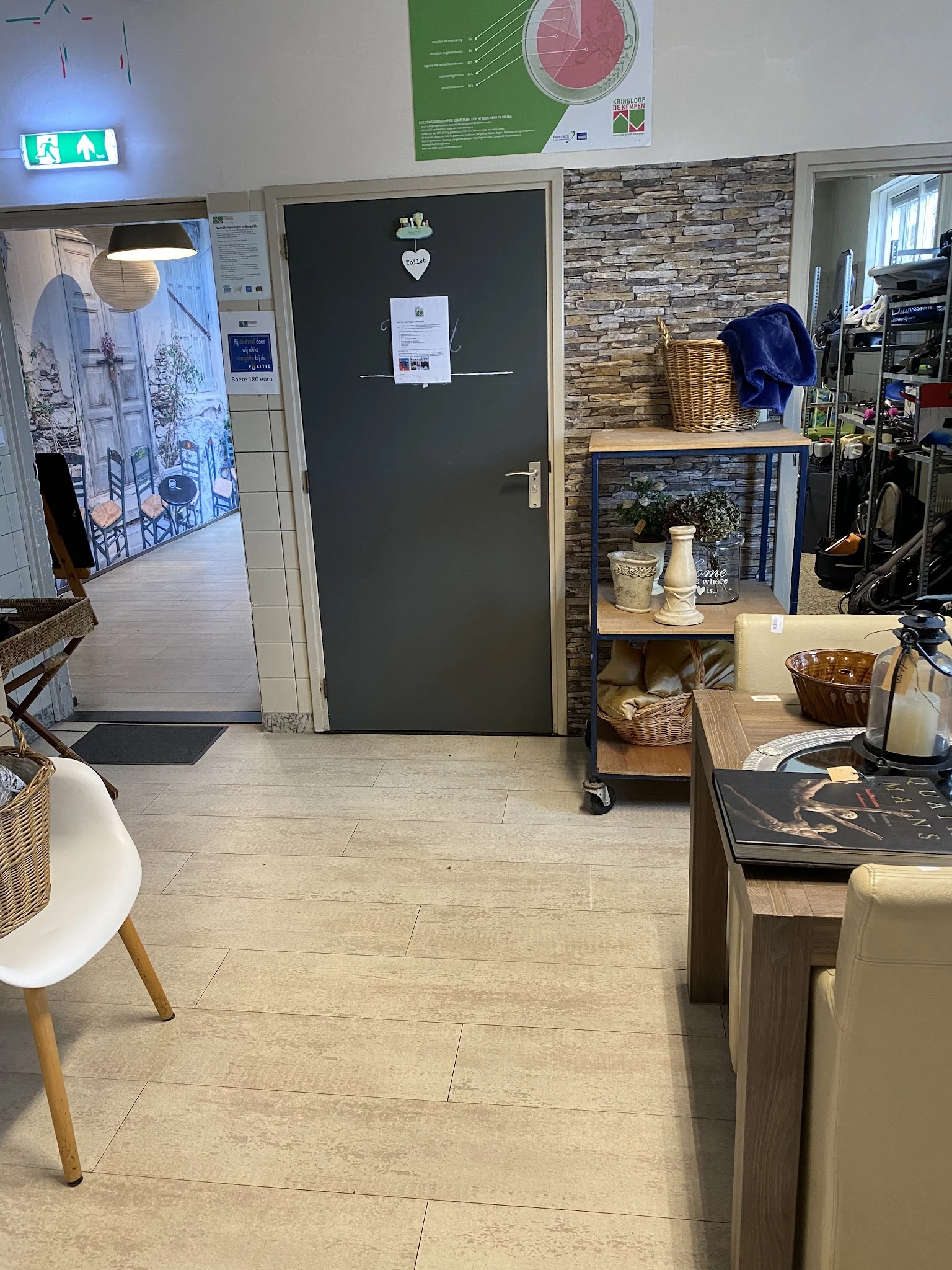 Winkelvloer met stellingkast, decoratieve items en baskets in kringloopwinkel