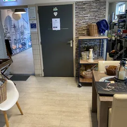 Winkelvloer met stellingkast, decoratieve items en baskets in kringloopwinkel