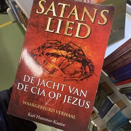 Close-up van een rood boek met gouden letters en een afbeelding van een doornenkroon op de kaft
