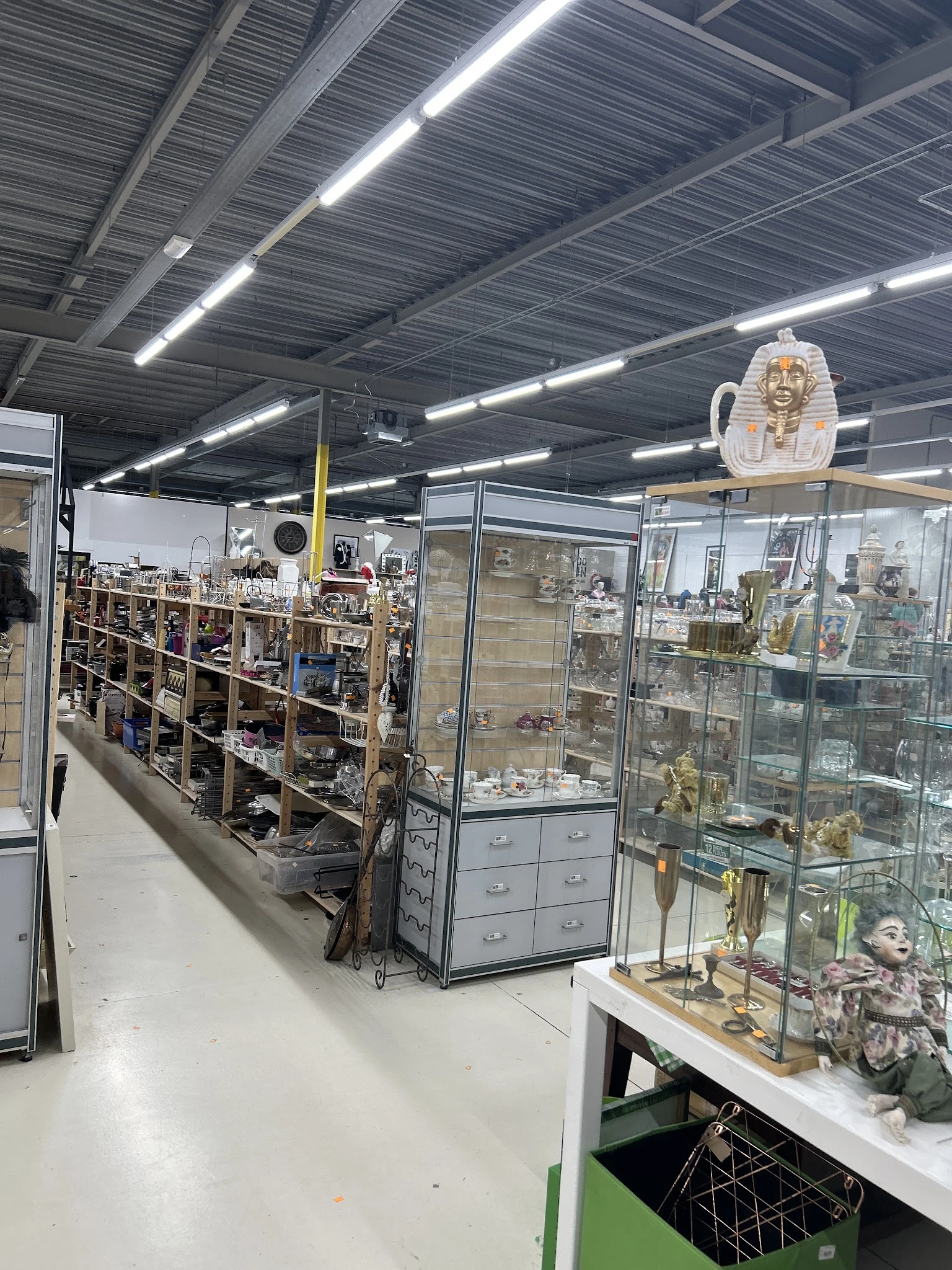 Winkelinterieur met stellingen vol decoratieartikelen en glazen vitrines met beeldjes en collectibles