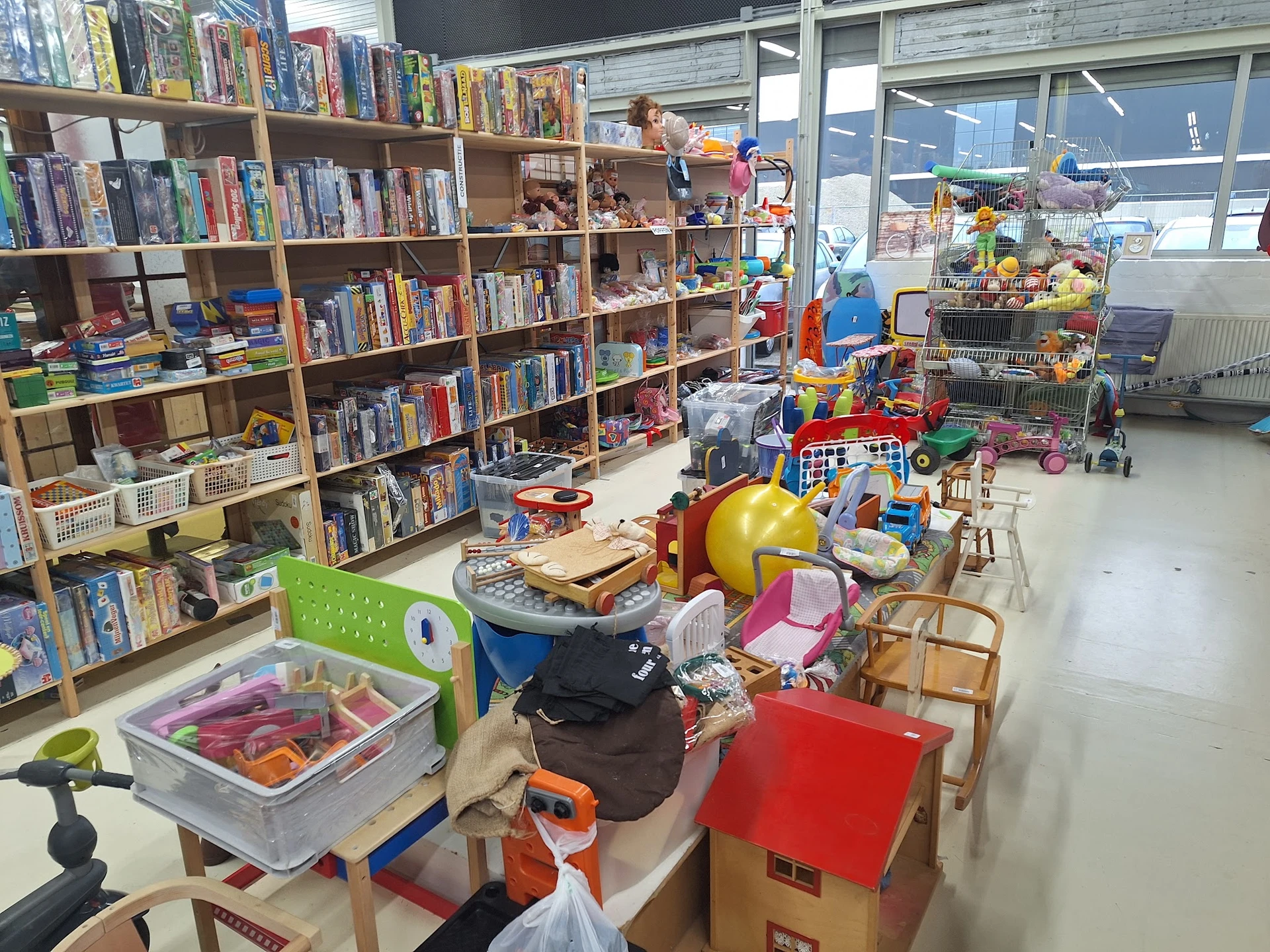 Winkelvloer met boekenkasten, speelgoed, huishoudspullen en verschillende artikelen uitgestald