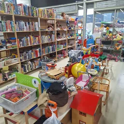 Winkelvloer met boekenkasten, speelgoed, huishoudspullen en verschillende artikelen uitgestald