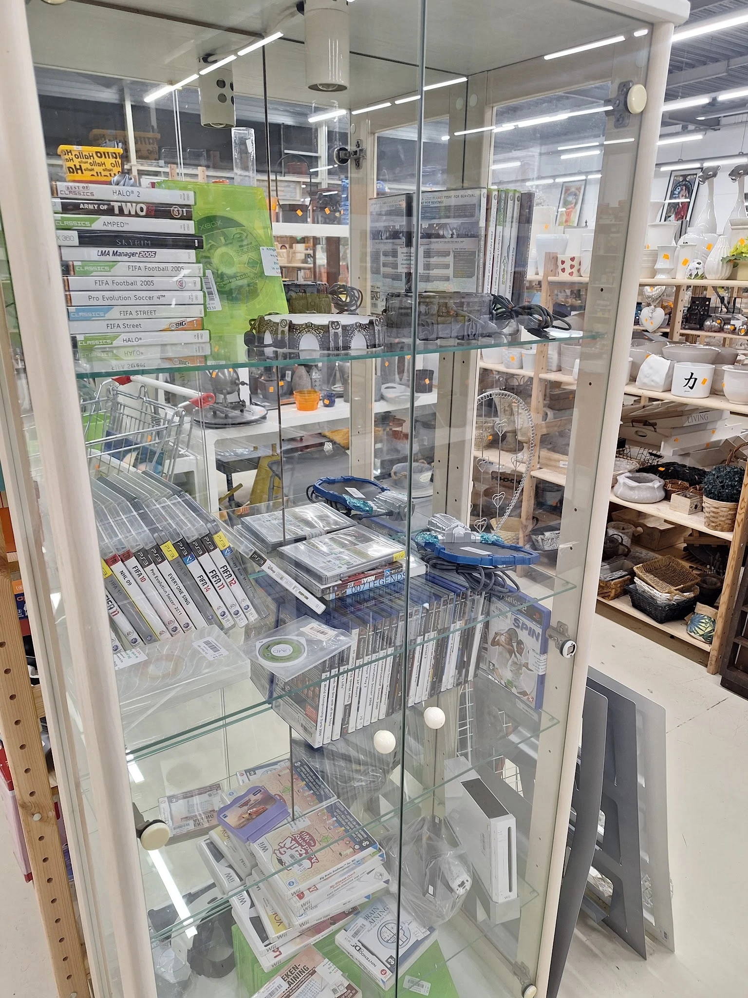 Glazen vitrinekast met dvd's, games en diverse collectibles netjes uitgestald