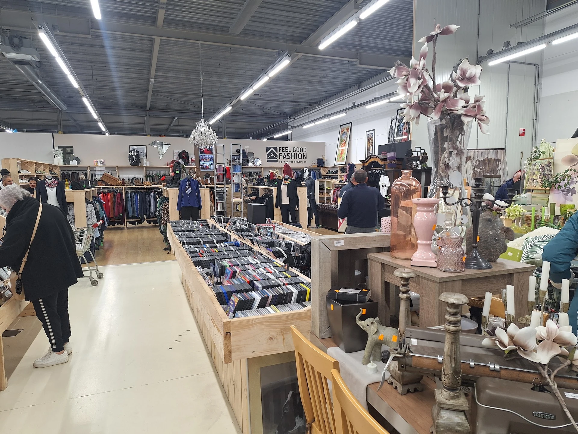 Overzicht van kringloopwinkel met kleding, huishoudartikelen en decoratie uitgestald