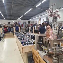 Overzicht van kringloopwinkel met kleding, huishoudartikelen en decoratie uitgestald
