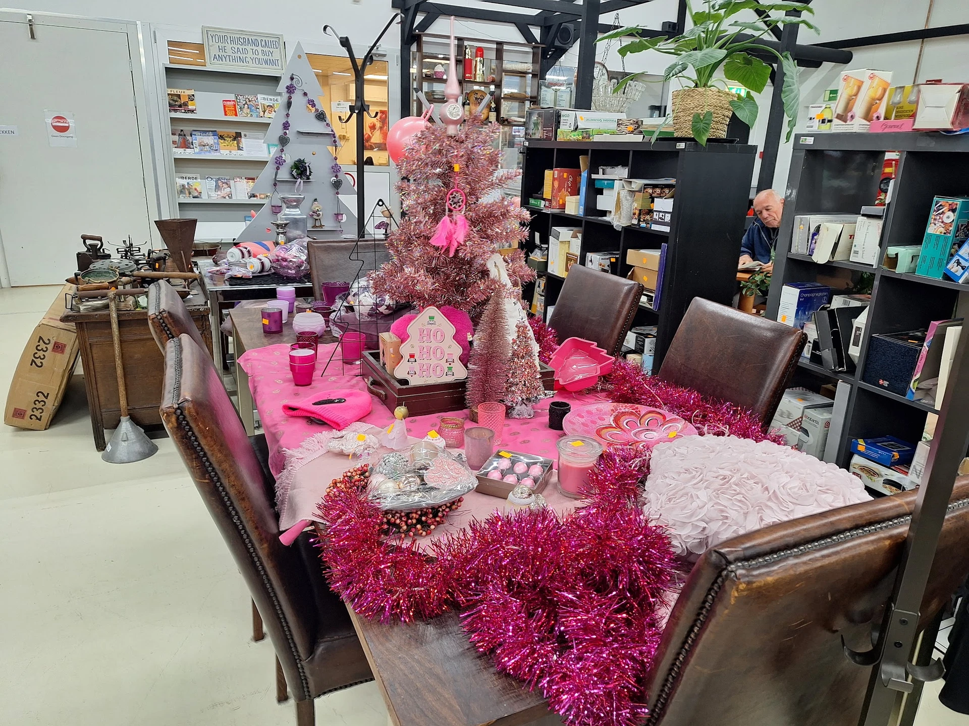 Tafel met roze decoraties, kaarsen en sieraden in kringloopwinkel
