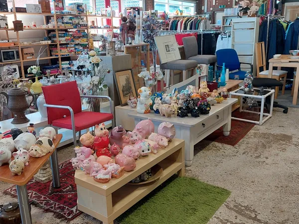 Winkelvloer met uitgestalde spullen: knuffels, meubels, kleding en huishoudartikelen in verschillende secties