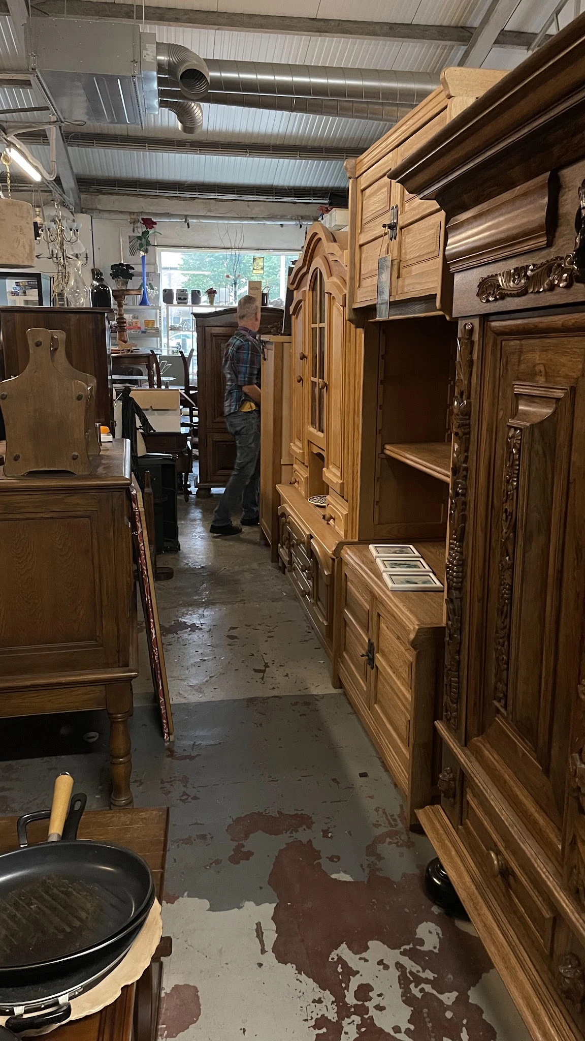 Winkelinterieur met houten kasten en meubels langs beide zijden van een gangpad
