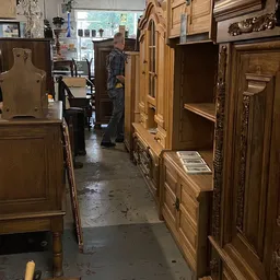 Winkelinterieur met houten kasten en meubels langs beide zijden van een gangpad