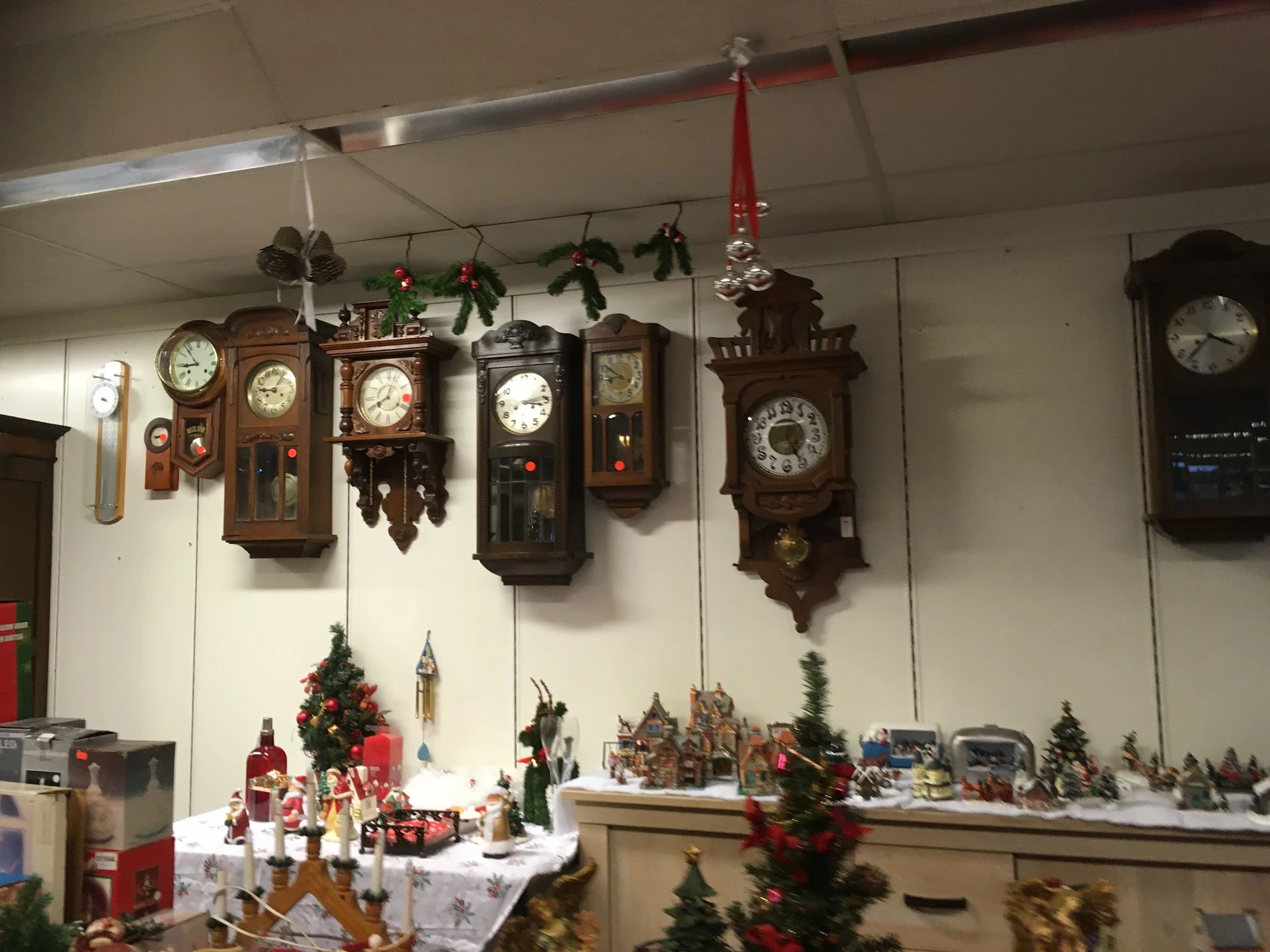 Verzameling antieke wandklokken en kerstdecoraties in een kringloopwinkel