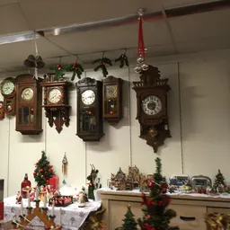 Verzameling antieke wandklokken en kerstdecoraties in een kringloopwinkel
