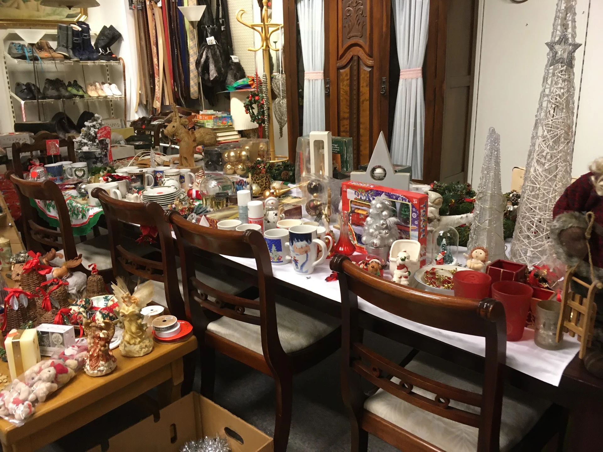 Winkelbinnenruimte met kerstaccessoires, decoraties en huishoudartikelen op tafels en stellingen
