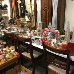 Winkelbinnenruimte met kerstaccessoires, decoraties en huishoudartikelen op tafels en stellingen