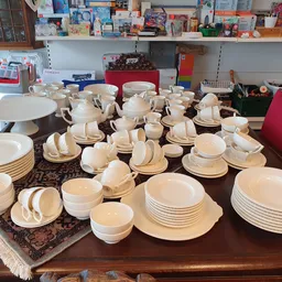 Tafelserviezen en borden in verschillende formaten uitgestald op een houten tafel