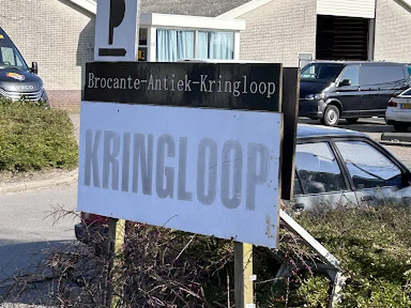 Straatnaambord en winkelnaambord van kringloopwinkel aan de gevel