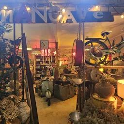 Vintage winkelinterieur met fietsen, lampen, meubels en decoratieve objecten onder warme gele verlichting