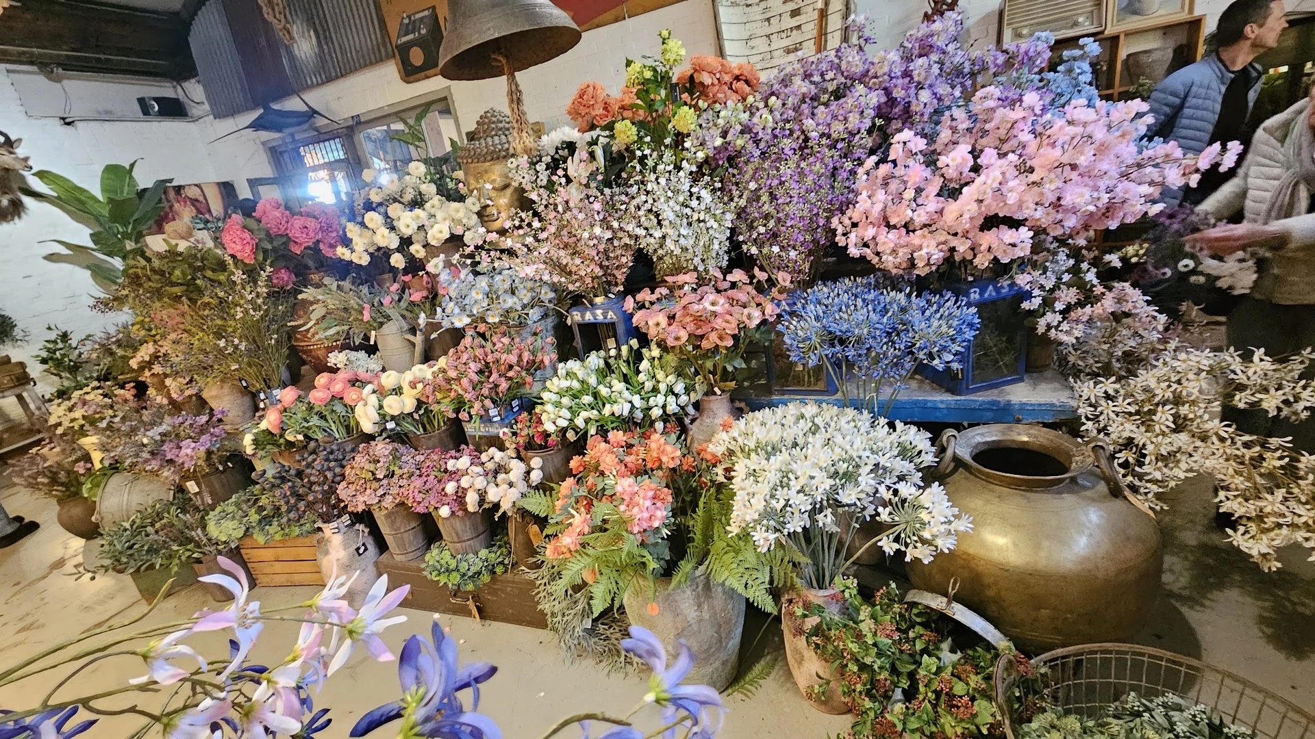 Uitgestalde kunstbloemen in verschillende kleuren en soorten in vazen en boeketten in de winkel