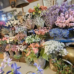 Uitgestalde kunstbloemen in verschillende kleuren en soorten in vazen en boeketten in de winkel