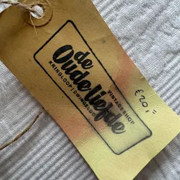 Close-up van een vintage label met zwarte tekst op geel-beige achtergrond