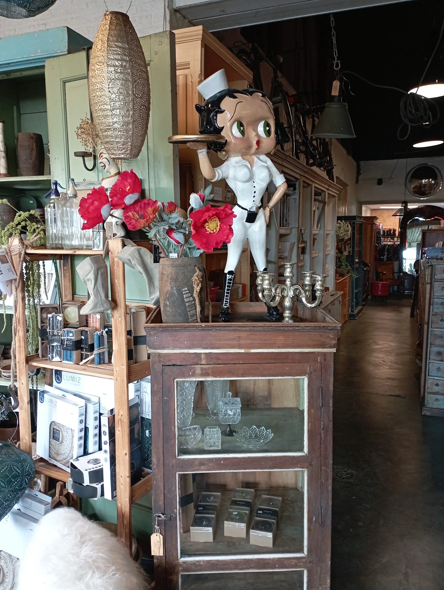 Vintage en antieke spullen op display: beelden, bloemen in vaas, kandelaar en decoratieve items