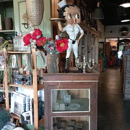 Vintage en antieke spullen op display: beelden, bloemen in vaas, kandelaar en decoratieve items
