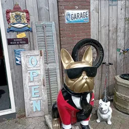 Gouden Franse bulldog-beeldje met zonnebril en rode blazer, een decoratief item in de kringloopwinkel