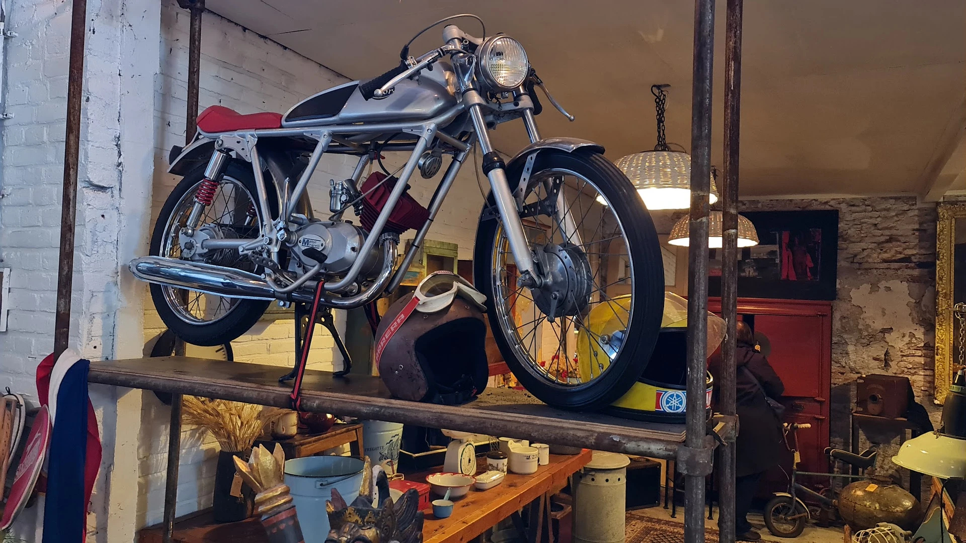 Vintage motorfiets met zwart-wit frame en rode accenten op een houten verhogde display