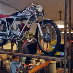 Vintage motorfiets met zwart-wit frame en rode accenten op een houten verhogde display