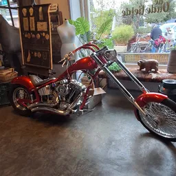 Rode chopper-motorfiets met uitgestalde onderdelen in een kringloopwinkel
